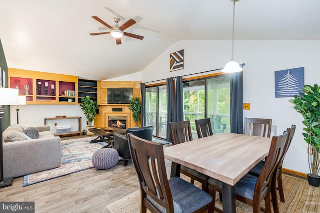 371 Oak Hill Rd, Berkeley Springs, WV 25411 - dining area with a lit fireplace, a ceiling fan, light wood finished floors, and lofted ceiling