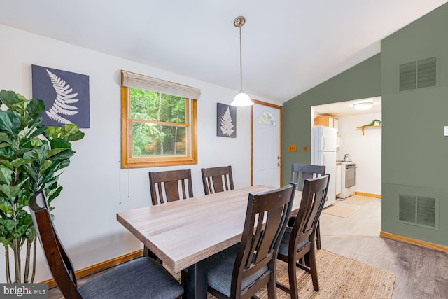 371 Oak Hill Rd, Berkeley Springs, WV 25411 - dining space with baseboards, visible vents, vaulted ceiling, and light wood-type flooring