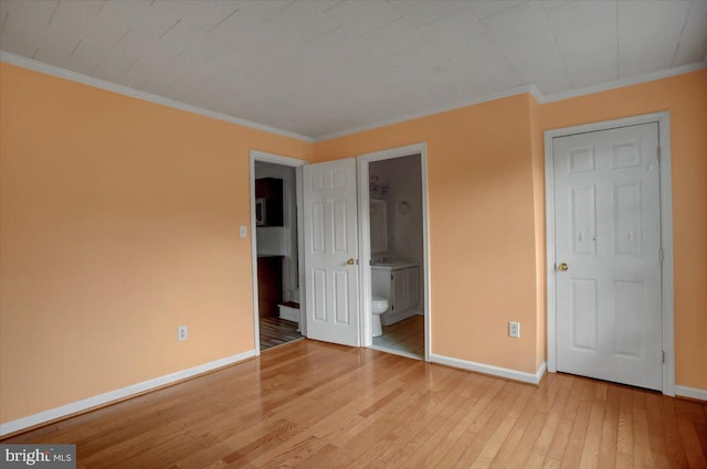 125 Cottage St, Waynesboro, PA 17268 - unfurnished bedroom featuring baseboards, wood finished floors, ornamental molding, and ensuite bathroom