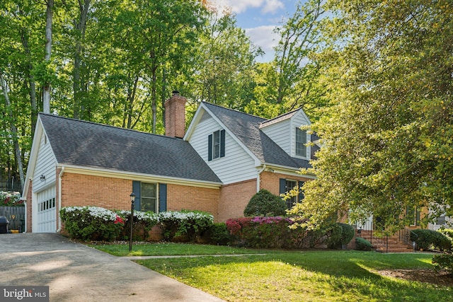 cape cod home with a chimney, roof with shingles, a front yard, a garage, and brick siding