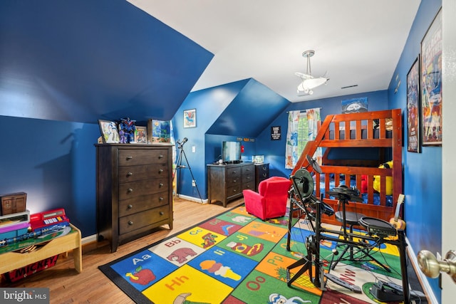 bedroom featuring baseboards, lofted ceiling, and wood finished floors