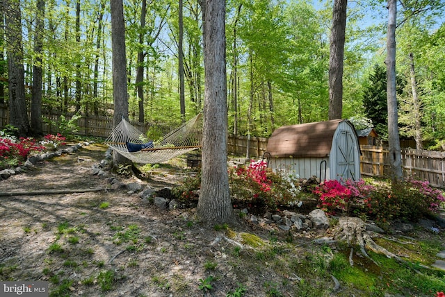 view of yard featuring a fenced backyard, an outbuilding, and a storage shed