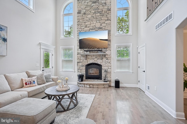 3357 Huntingdon Pike, Huntingdon Valley, PA 19006 - living room featuring a high ceiling, a stone fireplace, plenty of natural light, and hardwood / wood-style flooring