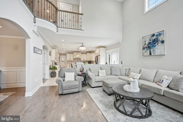 3357 Huntingdon Pike, Huntingdon Valley, PA 19006 - living area with arched walkways, healthy amount of natural light, crown molding, light wood finished floors, and a towering ceiling