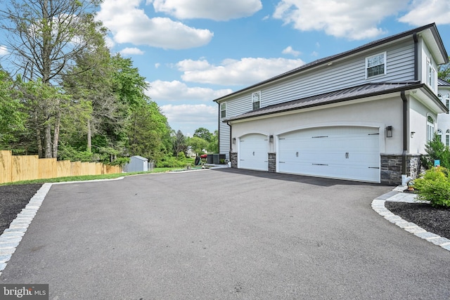 3357 Huntingdon Pike, Huntingdon Valley, PA 19006 - view of side of property featuring stone siding, asphalt driveway, metal roof, a standing seam roof, and a storage shed