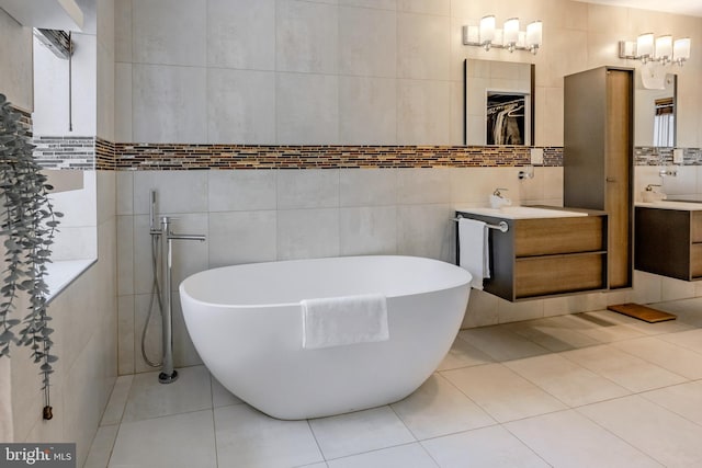 full bathroom with a freestanding tub, tile walls, and tile patterned flooring