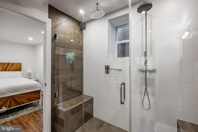 ensuite bathroom featuring a shower stall, wood finished floors, and connected bathroom
