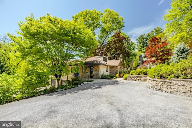 view of front of property with a chimney and stone siding