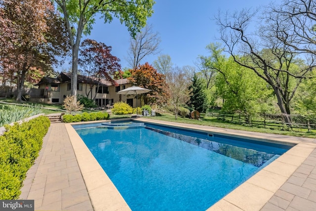 outdoor pool featuring fence