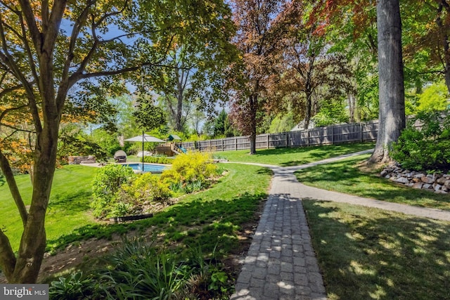 view of community with a lawn, fence, and a pool
