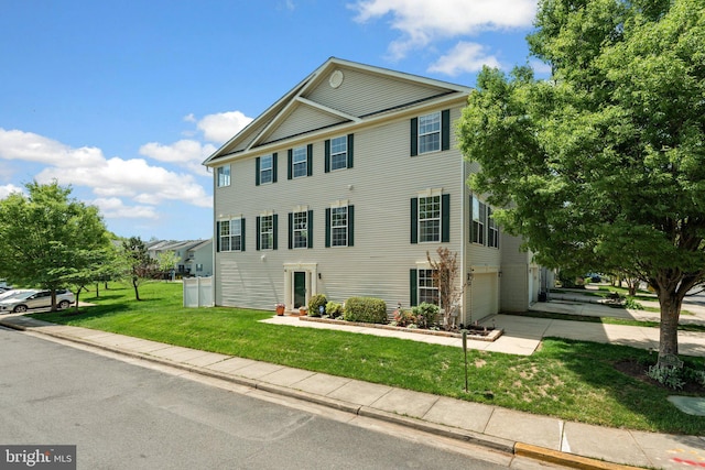 view of front of home with concrete driveway, a front yard, and a garage