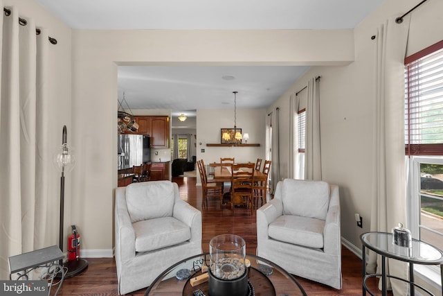 living room with baseboards, dark wood finished floors, and a notable chandelier