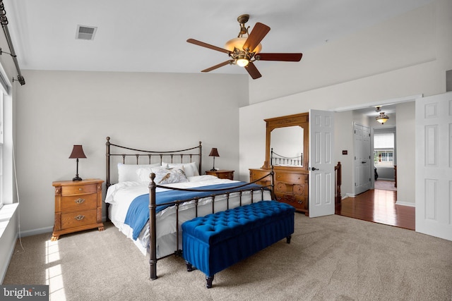 bedroom featuring visible vents, a ceiling fan, lofted ceiling, baseboards, and carpet flooring