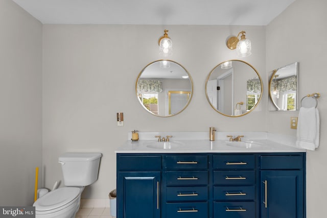 bathroom featuring a sink, tile patterned floors, toilet, and double vanity