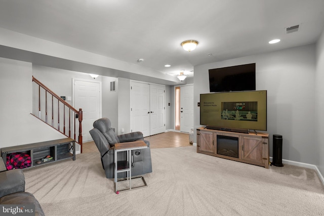 carpeted living area with recessed lighting, baseboards, stairs, and visible vents