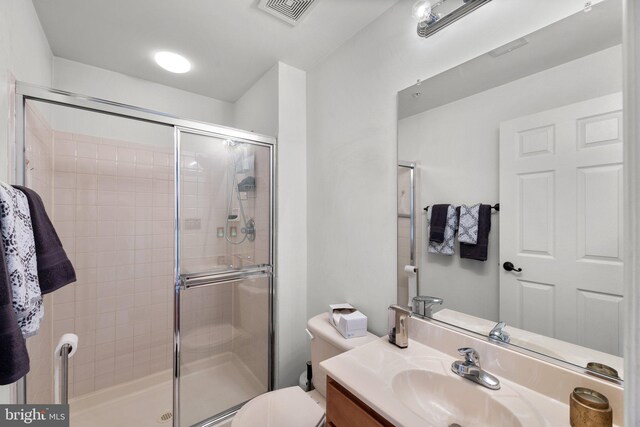 full bathroom featuring visible vents, vanity, toilet, and a shower stall