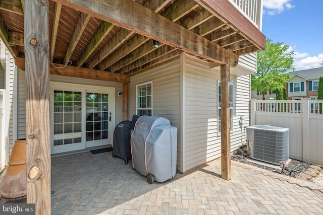 view of patio featuring central air condition unit, fence, and grilling area