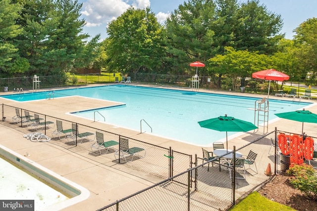 pool featuring fence and a patio