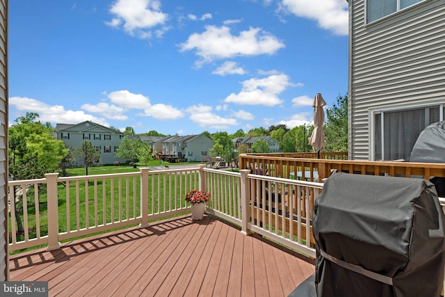 wooden terrace featuring a residential view, a lawn, and area for grilling