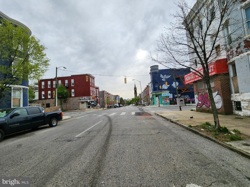 view of road featuring sidewalks, curbs, and street lights