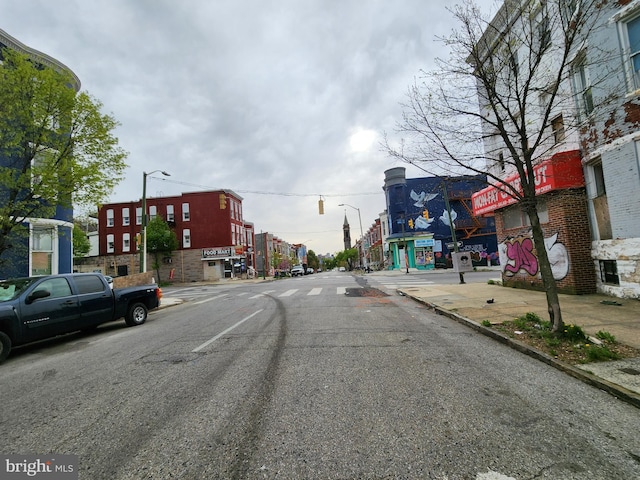 view of road featuring sidewalks, curbs, and street lights