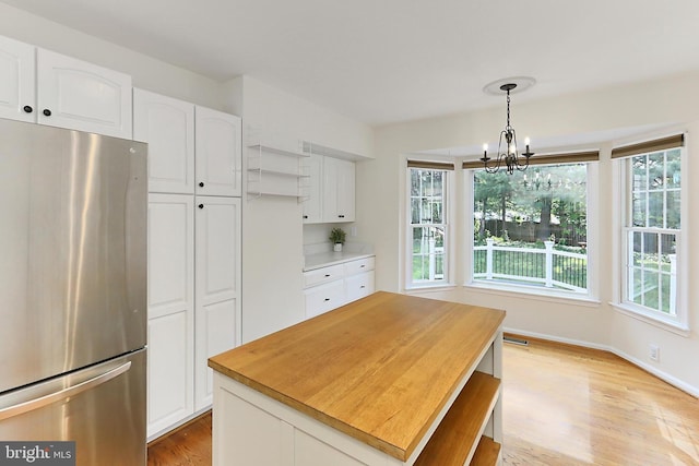 13407 Brookfield Dr, Chantilly, VA 20151 - kitchen with freestanding refrigerator, a chandelier, light wood-type flooring, white cabinetry, and pendant lighting