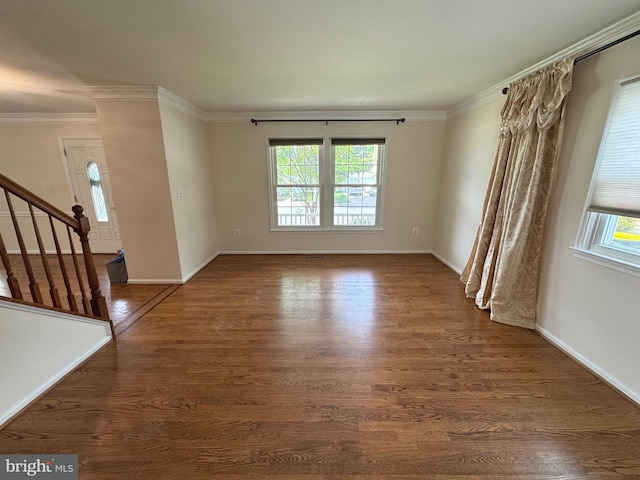 unfurnished living room with crown molding, baseboards, stairway, and wood finished floors