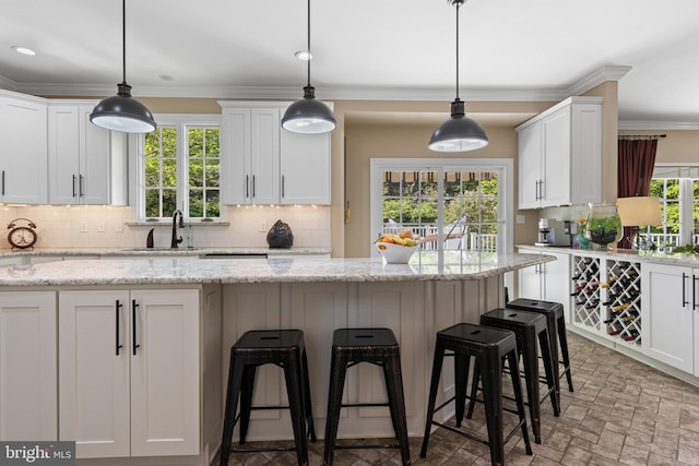 139 Watson Mill Rd, Landenberg, PA 19350 - kitchen featuring a sink, a kitchen bar, backsplash, white cabinets, and ornamental molding