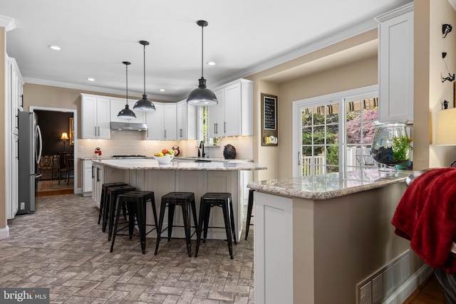 139 Watson Mill Rd, Landenberg, PA 19350 - kitchen featuring freestanding refrigerator, under cabinet range hood, backsplash, a sink, and white cabinets