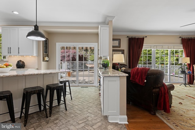 139 Watson Mill Rd, Landenberg, PA 19350 - kitchen featuring white cabinets, tasteful backsplash, ornamental molding, a breakfast bar area, and decorative light fixtures