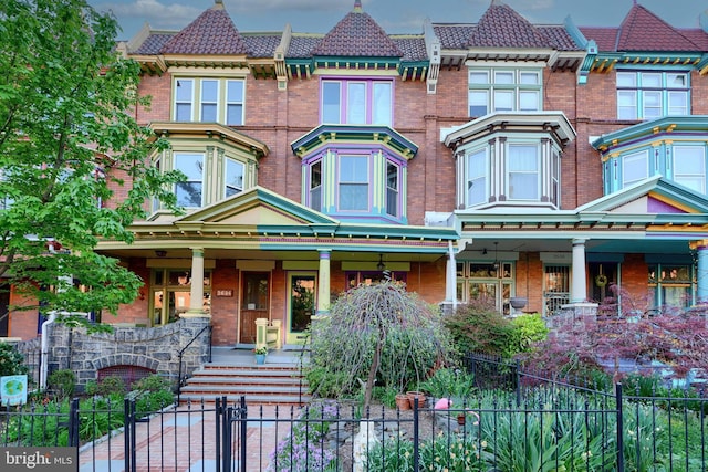 2636 N Calvert St N, Baltimore, MD 21218 - victorian house with covered porch, brick siding, a fenced front yard, and a tile roof