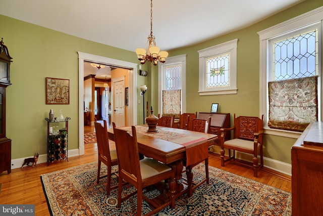 2636 N Calvert St N, Baltimore, MD 21218 - dining space featuring light wood-style floors, a chandelier, and baseboards