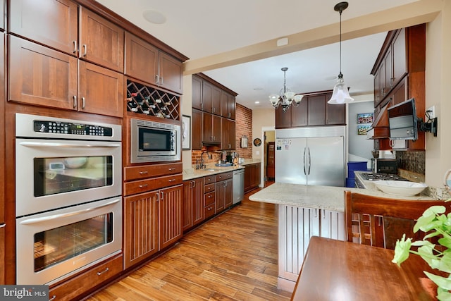 2636 N Calvert St N, Baltimore, MD 21218 - kitchen featuring built in appliances, light wood-type flooring, decorative backsplash, a chandelier, and recessed lighting