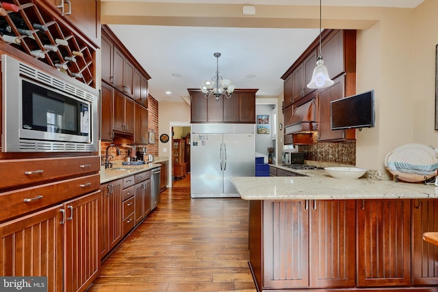 2636 N Calvert St N, Baltimore, MD 21218 - kitchen featuring built in appliances, hardwood / wood-style floors, a peninsula, tasteful backsplash, and recessed lighting