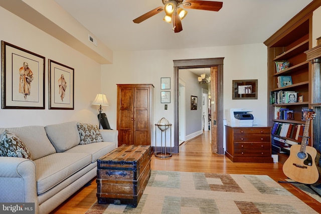 2636 N Calvert St N, Baltimore, MD 21218 - living room featuring a ceiling fan, wood finished floors, and baseboards