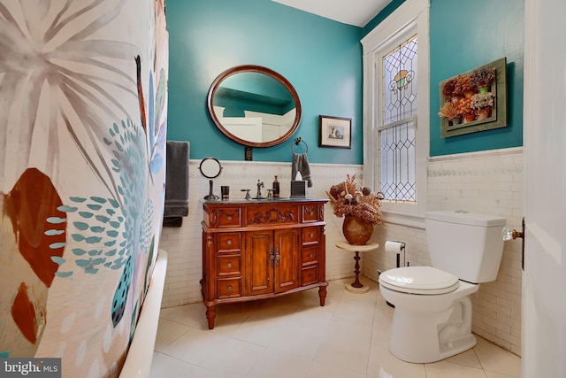 2636 N Calvert St N, Baltimore, MD 21218 - bathroom with tile walls, a wainscoted wall, toilet, tile patterned floors, and vanity