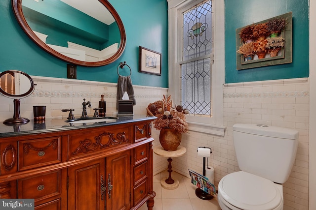 2636 N Calvert St N, Baltimore, MD 21218 - half bathroom with tile walls, tile patterned flooring, wainscoting, toilet, and vanity