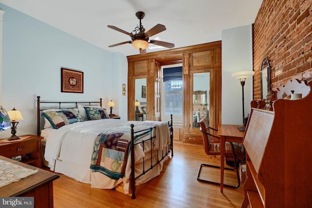 2636 N Calvert St N, Baltimore, MD 21218 - bedroom featuring light wood-style flooring, ceiling fan, and brick wall
