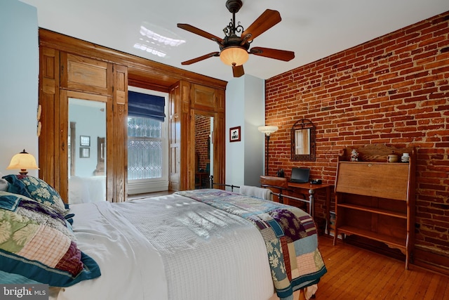 2636 N Calvert St N, Baltimore, MD 21218 - bedroom featuring brick wall, hardwood / wood-style flooring, a ceiling fan, and access to exterior