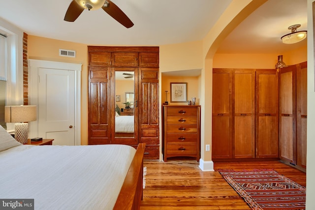 2636 N Calvert St N, Baltimore, MD 21218 - bedroom with arched walkways, wood finished floors, and a ceiling fan