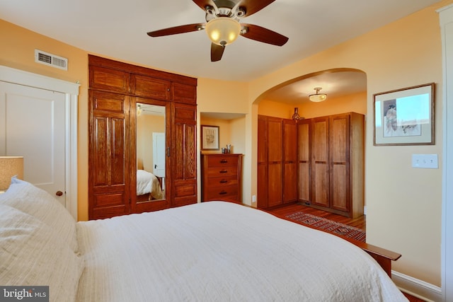 2636 N Calvert St N, Baltimore, MD 21218 - bedroom with arched walkways, baseboards, ceiling fan, and dark wood-style floors