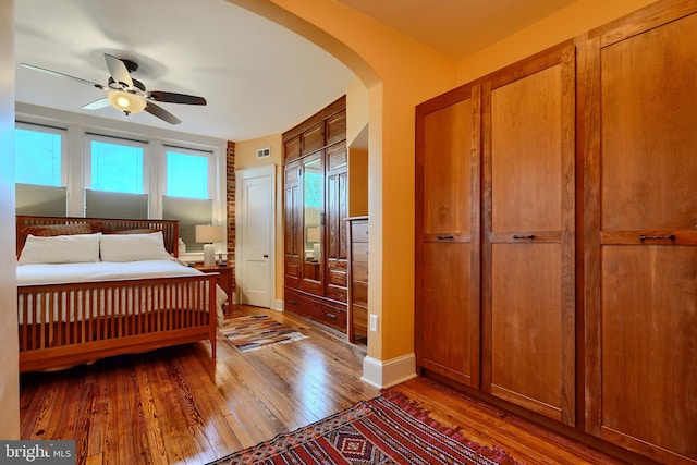 2636 N Calvert St N, Baltimore, MD 21218 - bedroom featuring arched walkways, hardwood / wood-style floors, baseboards, and a ceiling fan