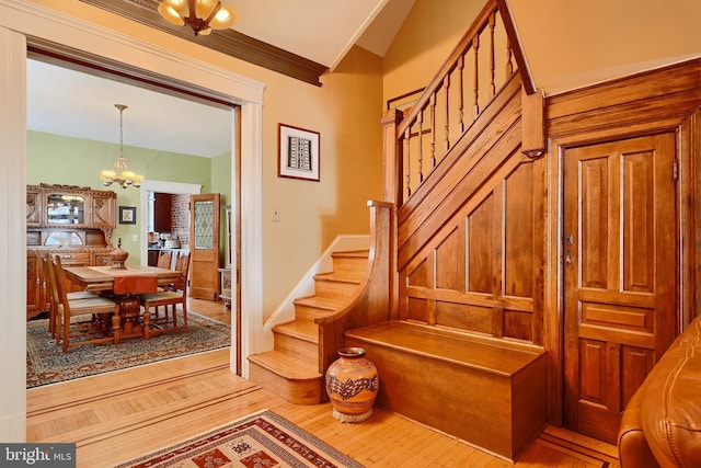 2636 N Calvert St N, Baltimore, MD 21218 - stairs with a chandelier, wood finished floors, vaulted ceiling, and crown molding