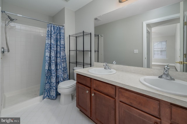 bathroom with a sink, tile patterned floors, a shower stall, and double vanity