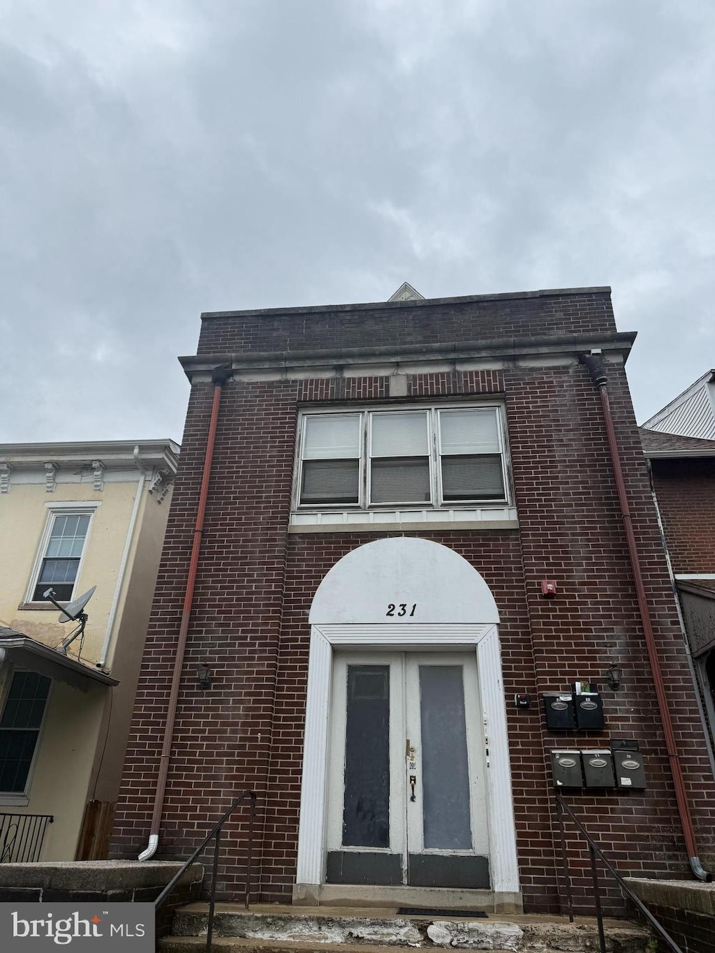 townhome / multi-family property with french doors and brick siding