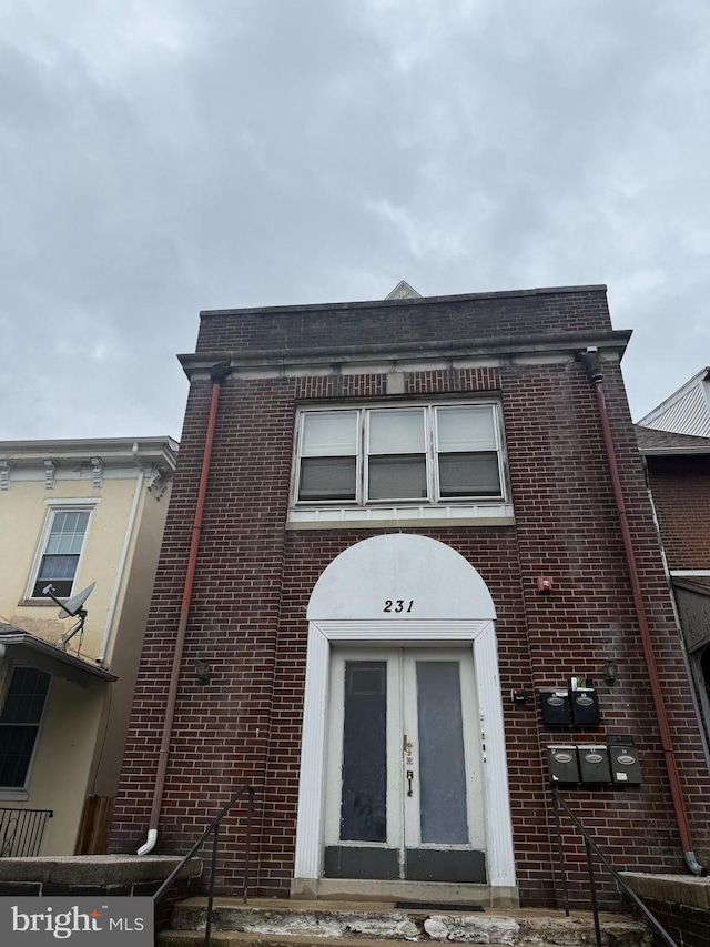 townhome / multi-family property with french doors and brick siding