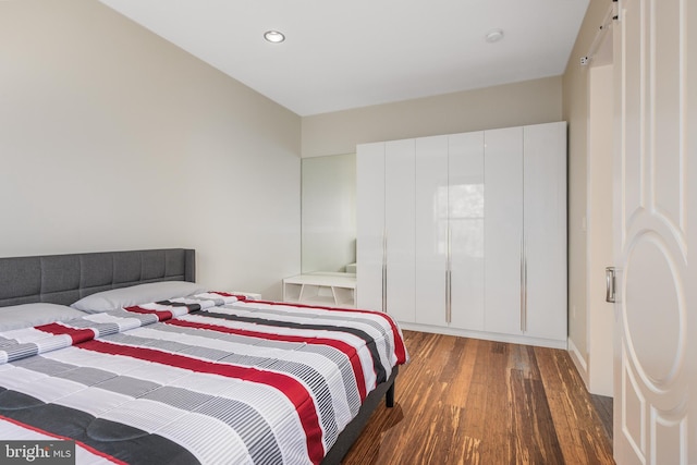 bedroom with wood finished floors and recessed lighting