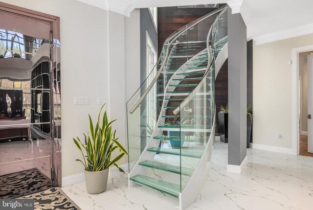 stairs featuring marble tiled floors, baseboards, and ornamental molding