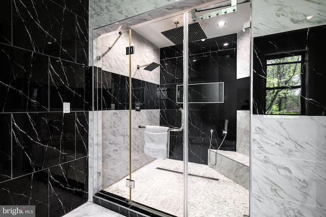 bathroom with tile walls, a marble finish shower, and marble finish flooring