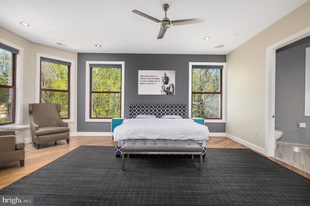 bedroom featuring multiple windows, wood finished floors, recessed lighting, and baseboards